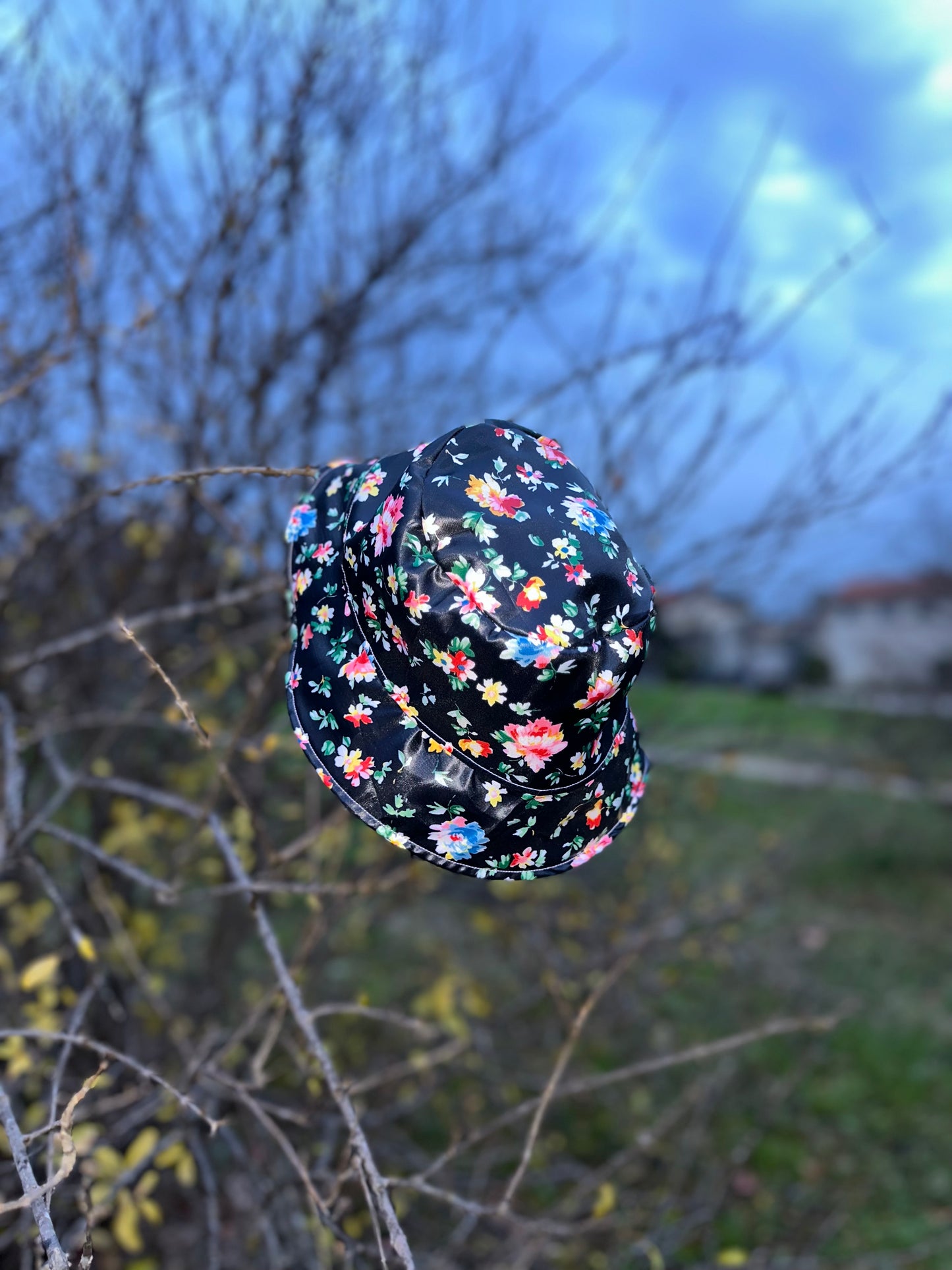 Bob réversible en tissu imperméable rose pâle et noir à fleurs