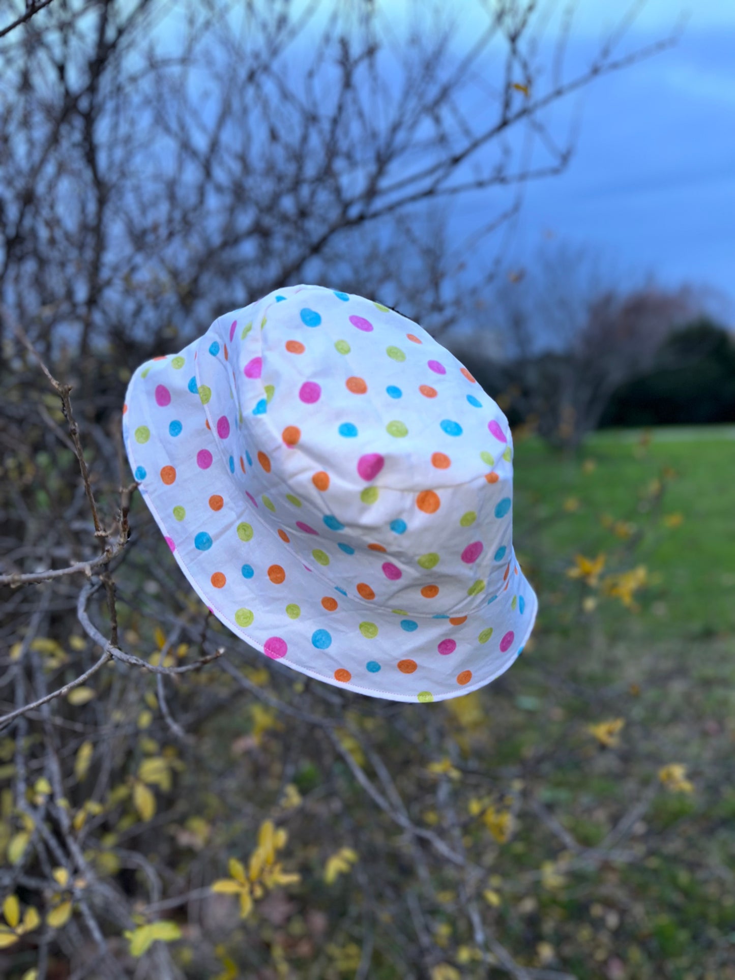 Bob réversible en tissu imperméable rose pâle et coton à pois multicolores