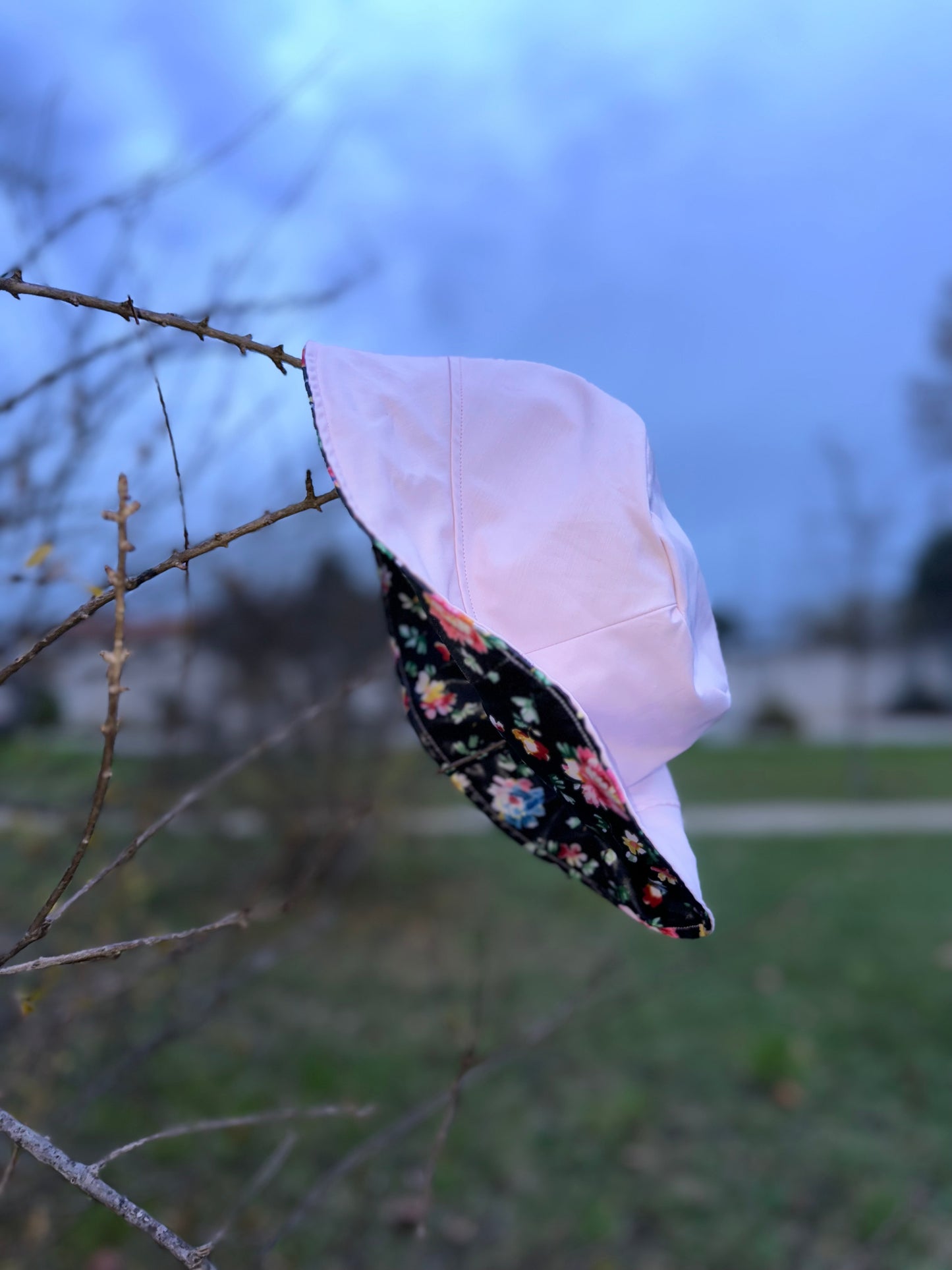Bob réversible en tissu imperméable rose pâle et noir à fleurs